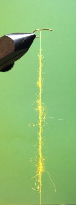 2.Bindeschritt:<br />Den Bindefaden mit Dubbingwax benetzen und diverses Dubbing an den "Waxfaden" anhalten und leicht andrücken. ACHTUNG Umso weniger das Dubbing um den Faden versponnen ist, desto schöner und fluffiger sieht der Körper später aus!